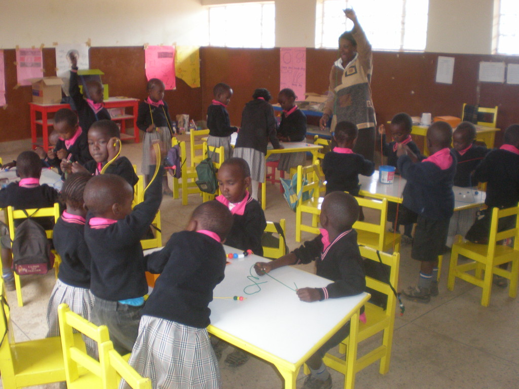 Baby class learning dexterity and their colours using beads.